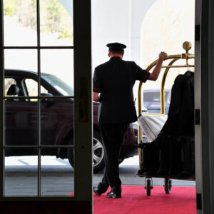 a-doorman-waiting-with-a-luggage-rack-while-waitin-2025-03-11-18-25-33-utc